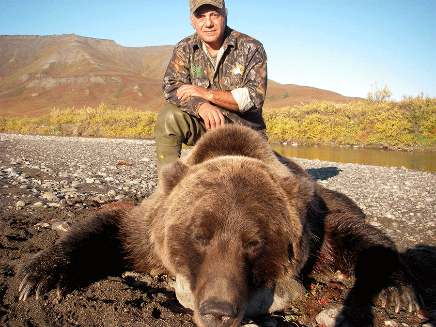 Grizzly bear hunter with his large bear.